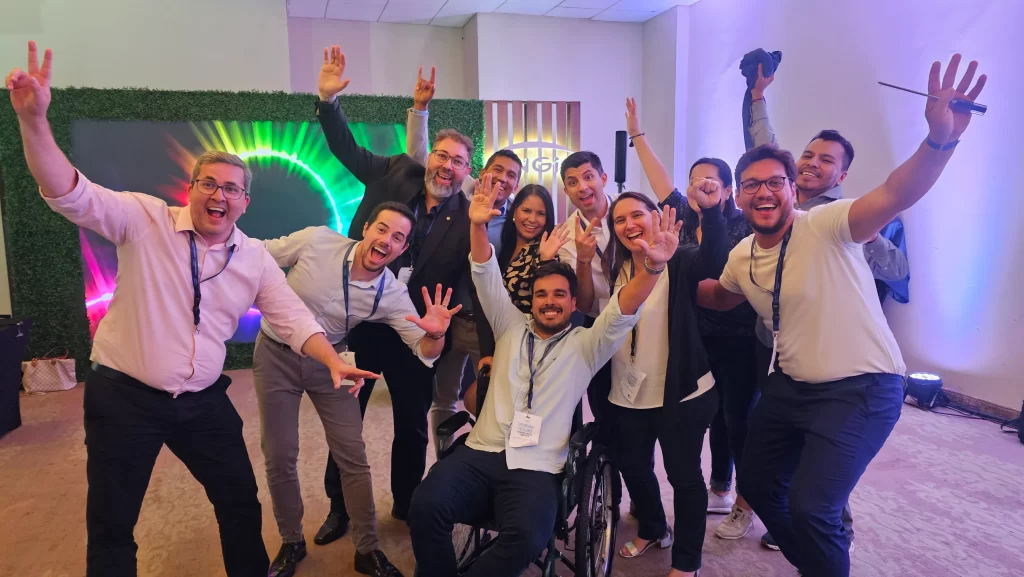 Equipo de personas sonrientes posando juntos en un taller de liderazgo, destacando la importancia de la colaboración y el trabajo en equipo para alcanzar objetivos comunes.