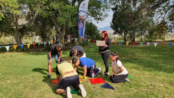 Colaboradores en una actividad de integración de equipos en el pasto.