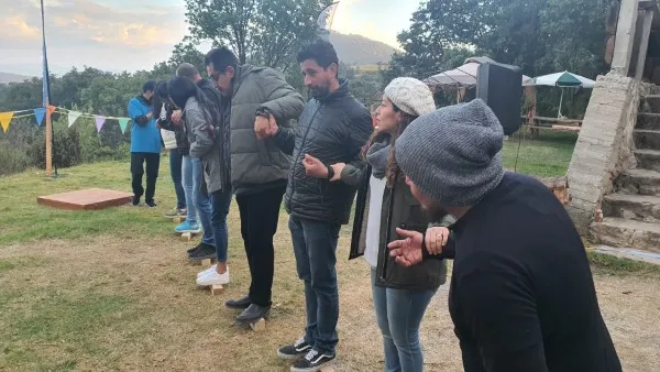 Miembros de un equipo agarrados de la mano como parte de los Talleres de comunicación.