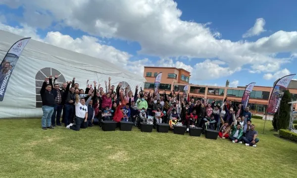 Colaboradores de una empresa se toman foto en un parque donde se ven felices después de una jornada de actividades como parte de una estrategia de desarrollo de equipos.