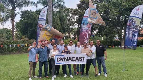 Grupo de personas posando para una foto con un cartel