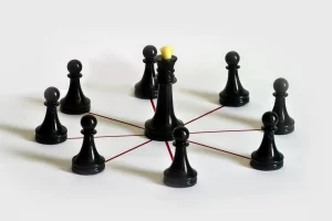 Estrategia en equipo y liderazgo representados en un tablero de ajedrez; simboliza el impacto del team building en la delegación y liderazgo.