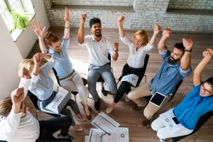 Colaboración y confianza en equipo; colegas levantan una torre con sus puños, destacando el impacto del team building en la cooperación.